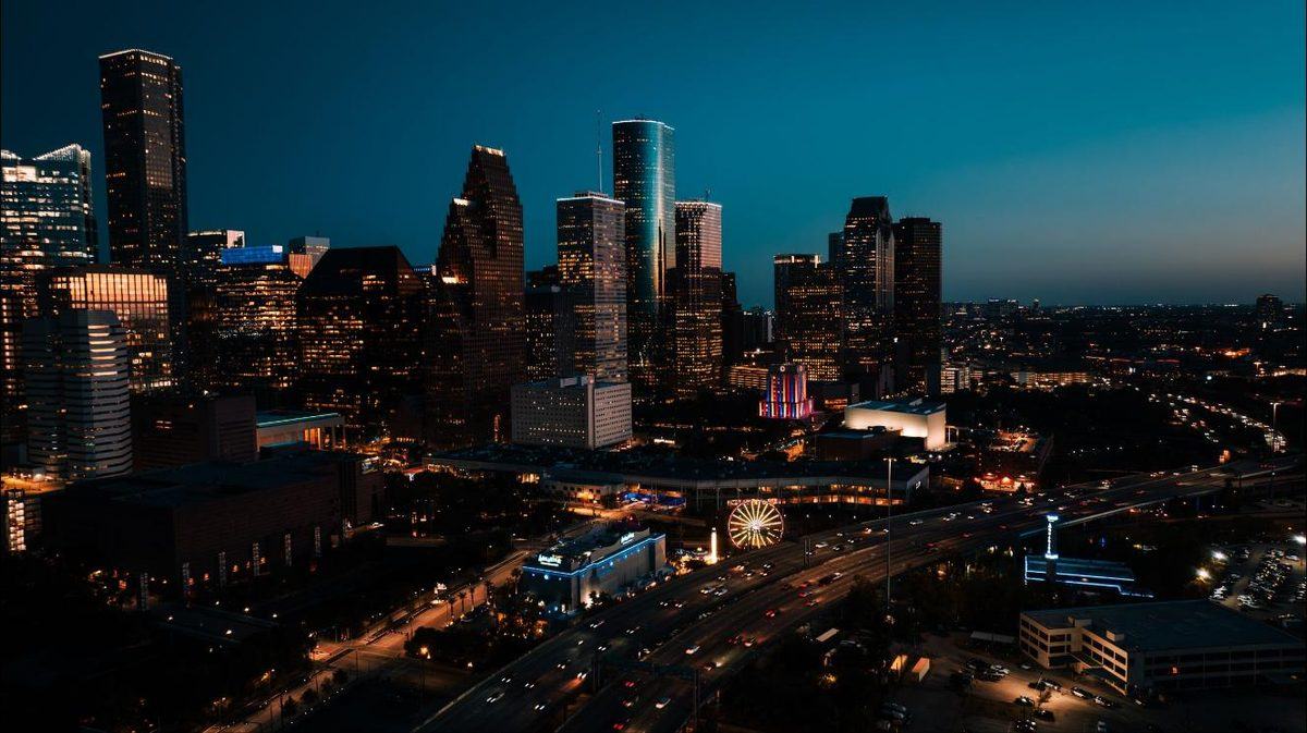 Downtown Houston skyline at dusk, seen from the north with the freeway in the foreground