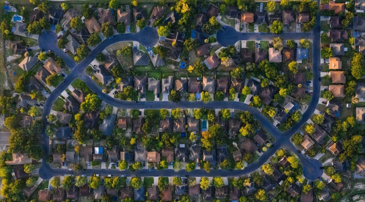 Overhead aerial view of an established suburban neighbourhood of detached homes among mature trees